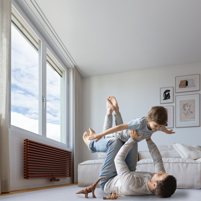 men and child playing on the fllor with a zehnder cleo radiator